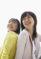 Wall Mural - Smiling girls sitting back to back