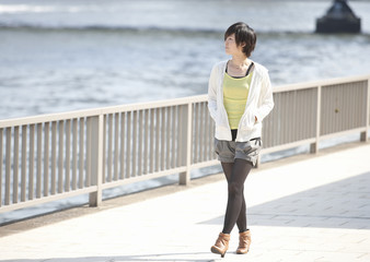 Canvas Print - Young woman walking along river