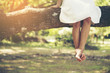 © aFotostock - Bare foot female legs sitting on the tree in the park.