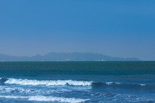 Seascape With Surf In Bay With Port City In Mountains