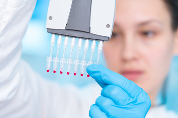 Poster - Woman technician with multipipette in genetic laboratory PCR research. Student girl use pipette. Young female scientist loads samples for DNA amplification by PCR