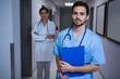 © WavebreakMediaMicro - Portrait of male nurse standing with doctor in background