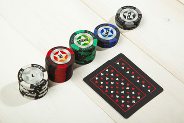 Game of poker chips and cards black on white wooden table