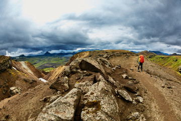 Wall Mural - woman hiker on the trail in the Islandic mountains. Trek in National Park Landmannalaugar, Iceland