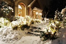 Front Of Home With Christmas Lights On Snowy Winter Night