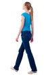 © ghoststone - back view of walking  woman  in   jeans and shirt.
