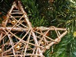 Fragment drewnianej gwiazdy bożonarodzeniowej na tle z gałązek świerkowych