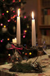 Burning candles on the background of multicolored christmas lights 