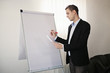 © Zdenka - Male adult man in a suit standing next to the white board, looki
