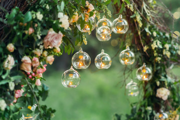 Wedding decor, candles in glass flasks in the forest