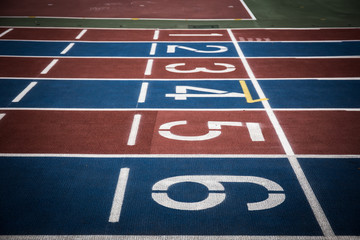 Running track with numbers from 1 to 6. Shot in a unique angle. Blue, red, white and green colors. Vignetting effect.