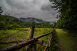 Old rustic fence surrounded by mountains in rain clouds day