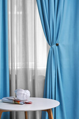 Wall Mural - Table and room window with white and blue curtains