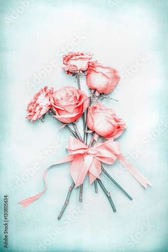 Foto Rollo Basic - Lovely romantic roses bunch with ribbon on blue background in pastel color, top view. (von VICUSCHKA)