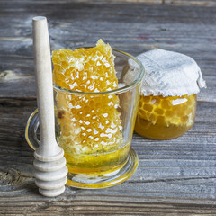 Wall Mural - Honeycomb in a glass on  simple wooden background. selective focus