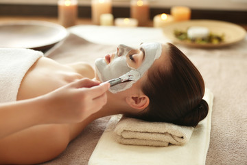 Sticker - Spa concept. Hand applying nourishing mask on female face in spa salon