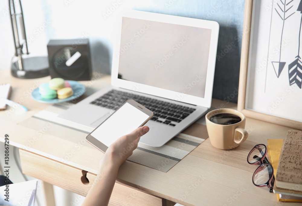 Woman with laptop and cellphone at home