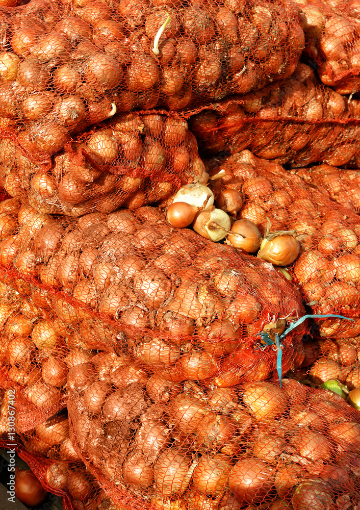 Mesh bags with fresh onion on market