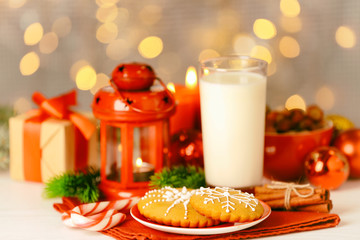 Wall Mural - Composition of tasty gingerbread cookies and glass of milk on kitchen table