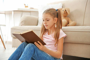 cute girl reading book at home