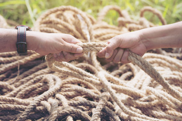 two people hands pulling the rope