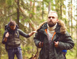 © Acronym - Man with a beard and his friend hiking in a forest