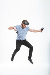 Wall Mural - Happy bearded man wearing virtual reality device while jumping