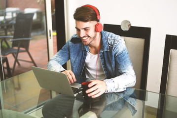 Young man sitting at the table using his laptop.