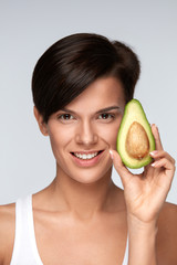 Wall Mural - Healthy Foods. Beautiful Smiling Woman With Green Avocado