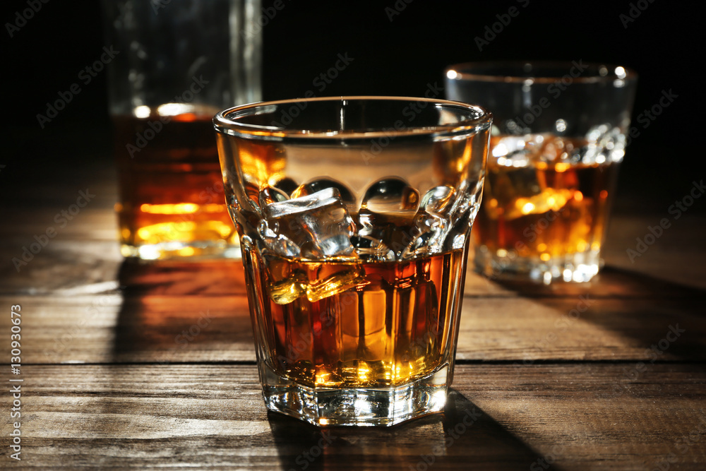 Glasses of whisky on wooden table closeup