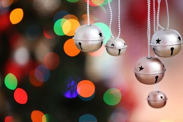 Canvas Print - Jingle bells on blurred Christmas lights background, closeup