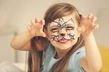 Portrait Of Funny Girl With Face Painting On Blurred Background