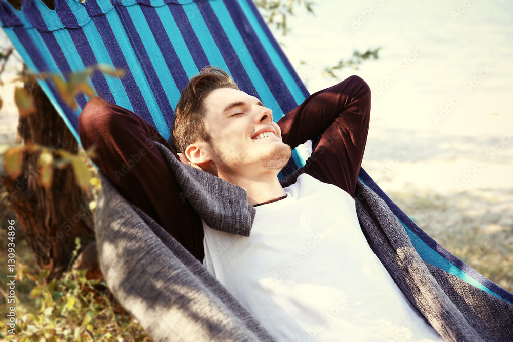 Handsome man relaxing in hammock