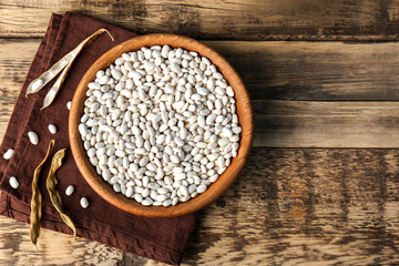 Poster - Bowl with white haricot beans and napkin on wooden table