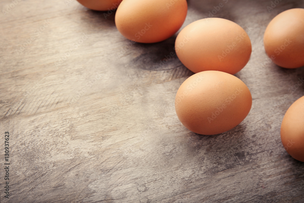 Raw eggs on wooden background