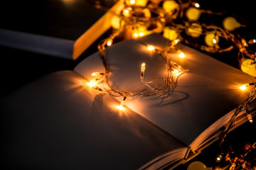 Wall Mural - Close up view of open book and beautiful garland on table