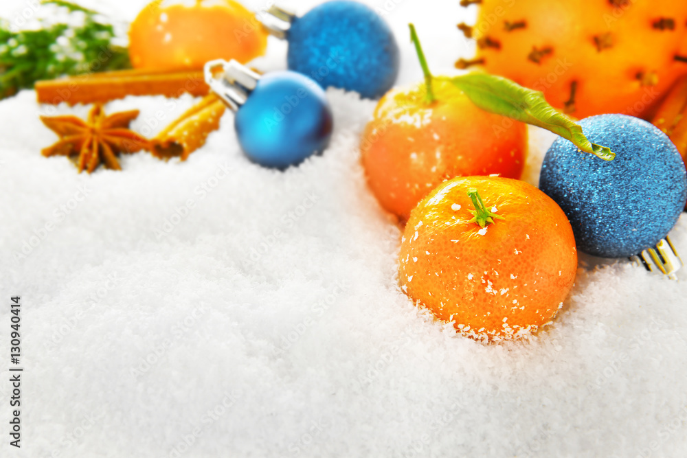 Christmas composition of citruses and spices on snow, closeup