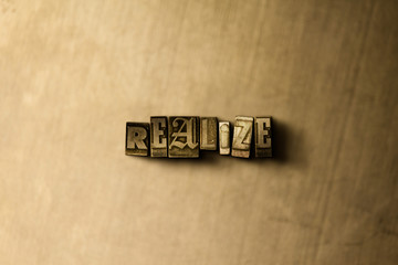 REALIZE - close-up of grungy vintage typeset word on metal backdrop. Royalty free stock - 3D rendered stock image.  Can be used for online banner ads and direct mail.