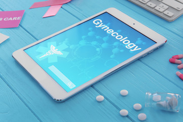 Wall Mural - Tablet with word GYNECOLOGY and pills on blue wooden background