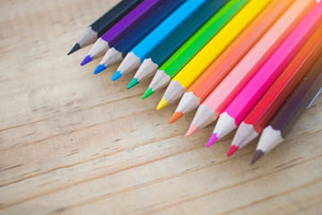 Close up of color pencils with different color over wood backgro