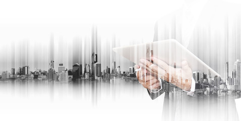 Businessman working on digital tablet with double exposure city, concepts of  business communication technology