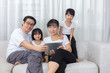 © Tan Kian Khoon - Happy Asian Chinese family using tablet on the couch