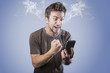 Angry man shouting at his cell phone, smoking with rage, smoke coming out his ears