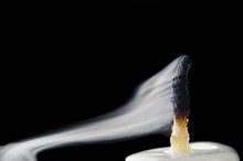 Damped Candle With Smoke On A Black Background