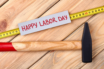 Labor Day card and hammer. Tools and card on wood. Symbolism of Labor Day.