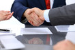 © rogerphoto - Two business man shaking hands to each other above signed contract