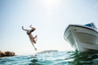 © Richard Schultz - Man flipping off a boat into the ocean.