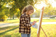 © Africa Studio - Young female artist painting picture in autumn park