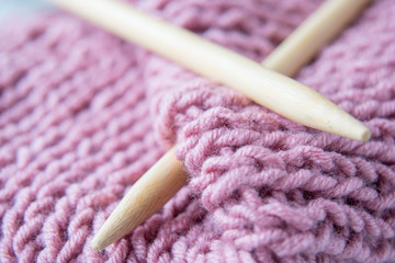 Two knitting spokes and knitted fabric close up