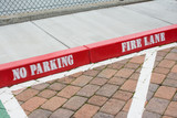 Fototapeta Desenie - Painted red curb with no parking and fire lane
